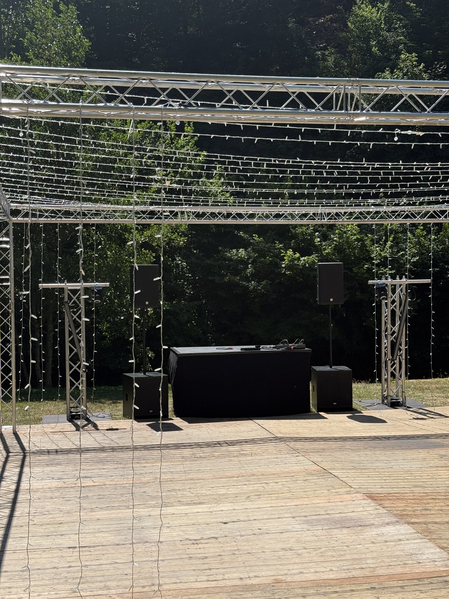 Traversendach mit Lichterketten über einer Tanzfläche im Freien