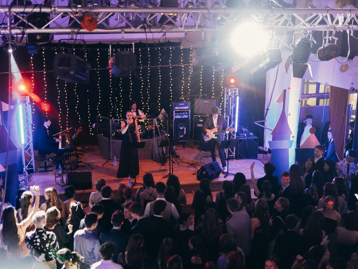 Live-Band auf der Bühne mit Moving Heads und Lichterketten vor Publikum