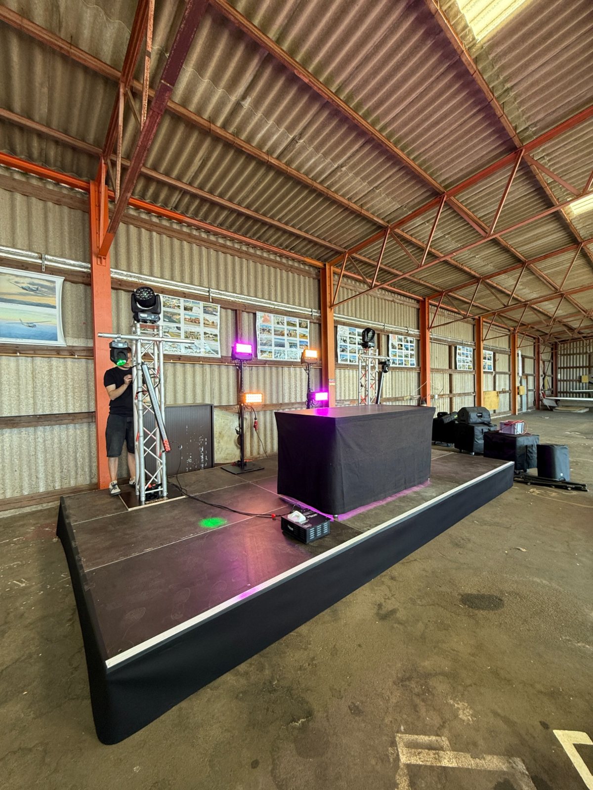 Bühne mit DJ-Pult, Traverse und Beschallung in einer Halle